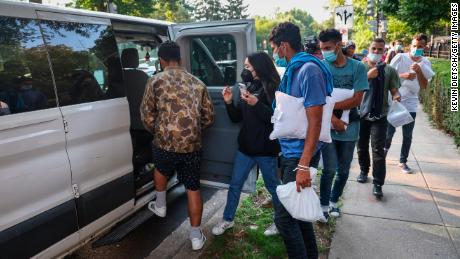 Migrants head into vans near the US Naval Observatory after being dropped off there Thursday. 