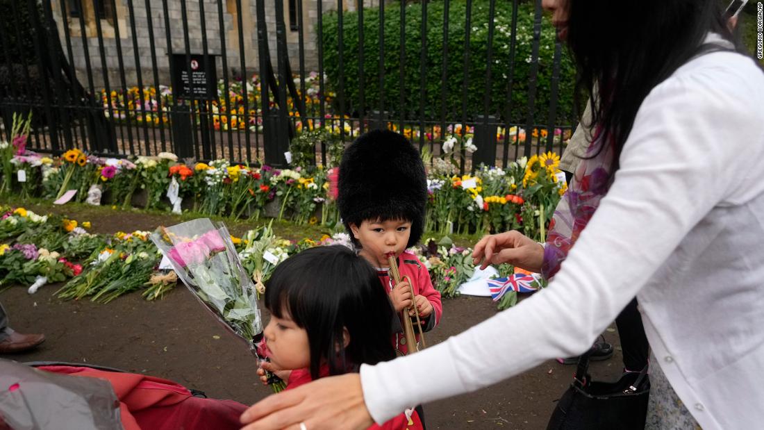 Sachiko Suckling and her 3 year-old twins, Naomi and Louis, lay flowers outside Windsor Castle on Thursday.