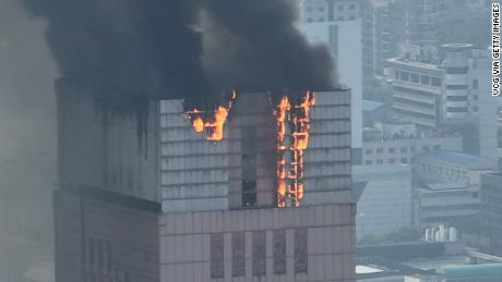 Flames and smoke rise from the 218-meter-tall office building in Changsha on September 16, 2022. 