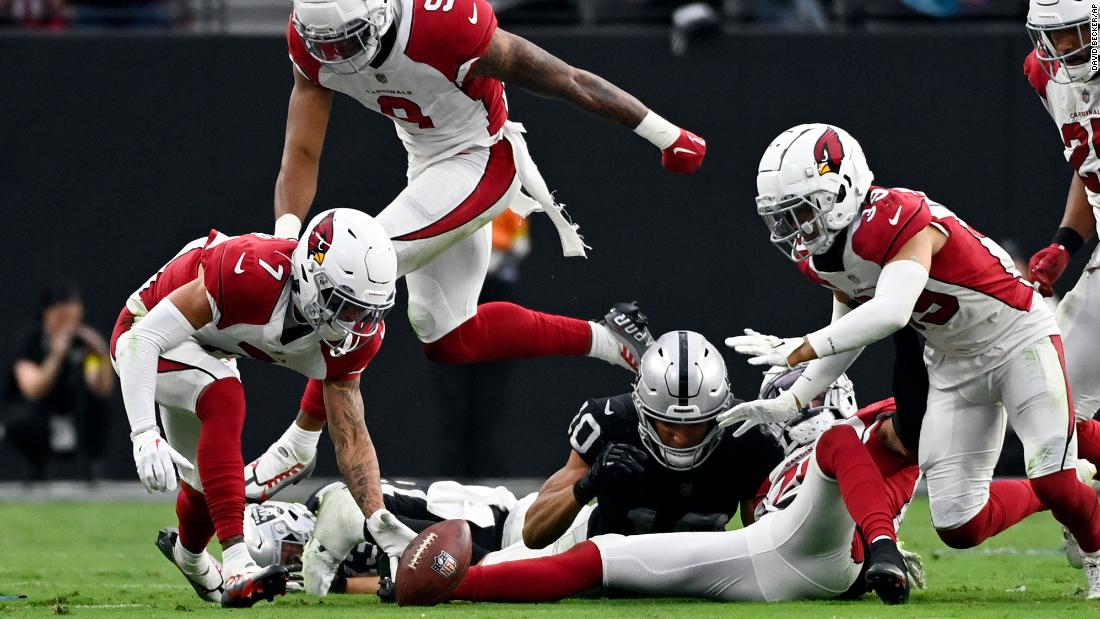 Arizona Cardinals cornerback Byron Murphy Jr., left, picks up a fumble and returns it for the winning touchdown during overtime of a dramatic 29-23 win against the Las Vegas Raiders on September 18. 