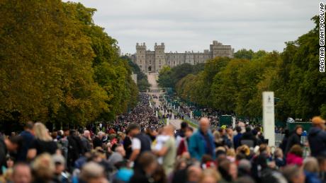 People stand along the Long Walk outside Windsor Castle as they wait for the coffin of Queen Elizabeth II to arrive.