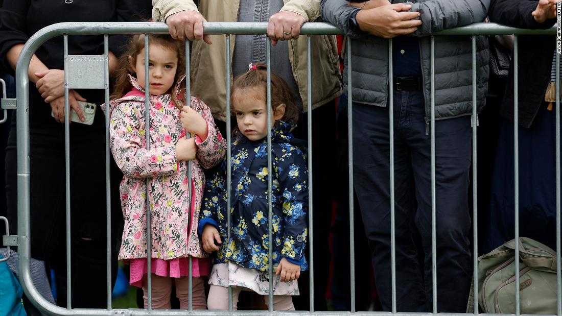 Children look through a fence in London, hoping to catch a glimpse of the procession.