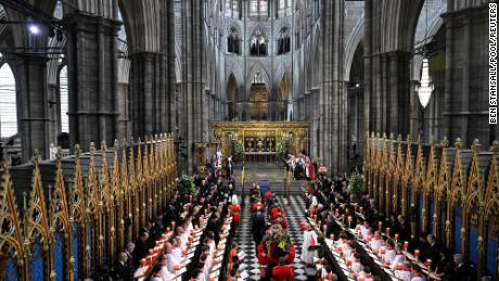 The Queen&#39;s coffin, draped in the Royal Standard, is carried inside Westminster Abbey.
