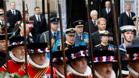 Prince William, Prince of Wales, Prince Richard, Duke of Gloucester, Prince Harry, Duke of Sussex, King Charles III, and Anne, Princess Royal, walk alongside Yeoman of the Guards.