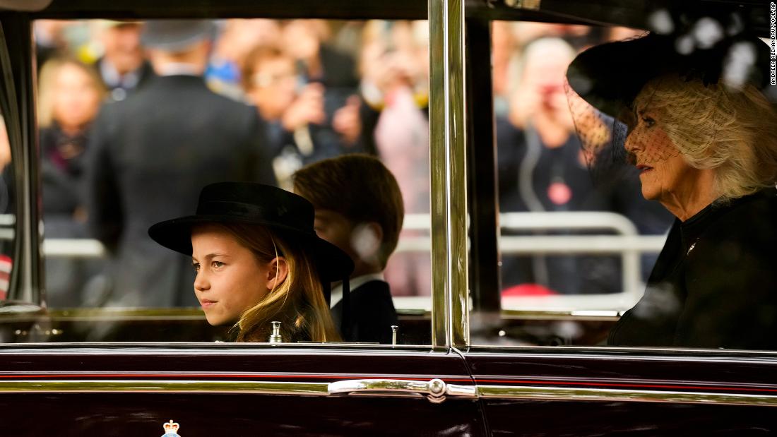 From left, Princess Charlotte, Prince George and Camilla, the Queen Consort, are seen in a vehicle outside Westminster Abbey.