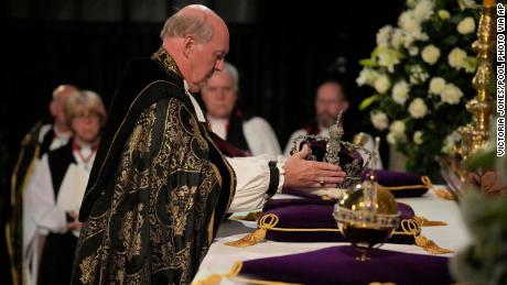 The Dean of Windsor, The Rt Revd David Conner, places the Imperial State Crown, and orb and sceptre during the committal service for Queen Elizabeth II, at St. George&#39;s Chapel, in Windsor, England, Monday Sept. 19, 2022. The Queen, who died aged 96 on Sept. 8, will be buried at Windsor alongside her late husband, Prince Philip, who died last year.  (Victoria Jones/Pool Photo via AP)