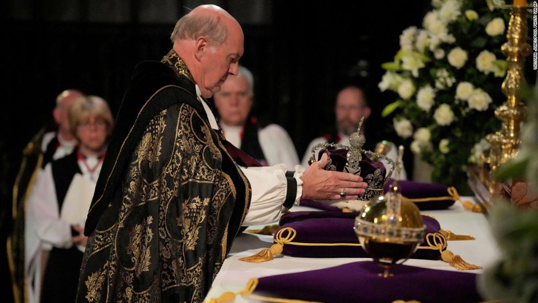 The Dean of Windsor, David Conner, places the Imperial State Crown and Orb and Sceptre on an altar during the committal service.