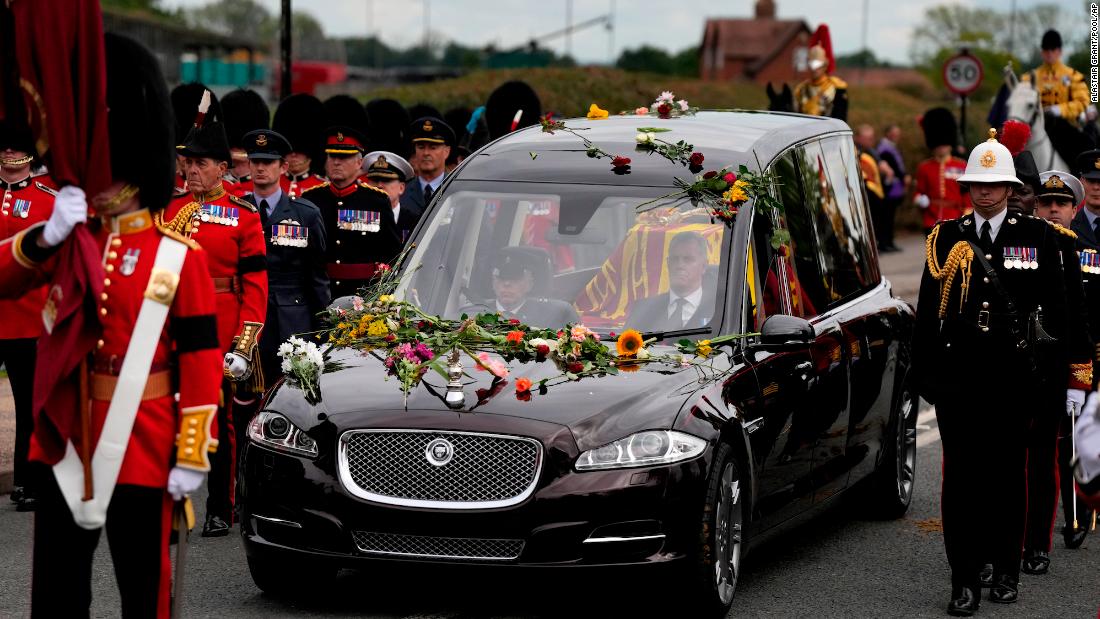 Flowers cover the hearse carrying the Queen&#39;s coffin.