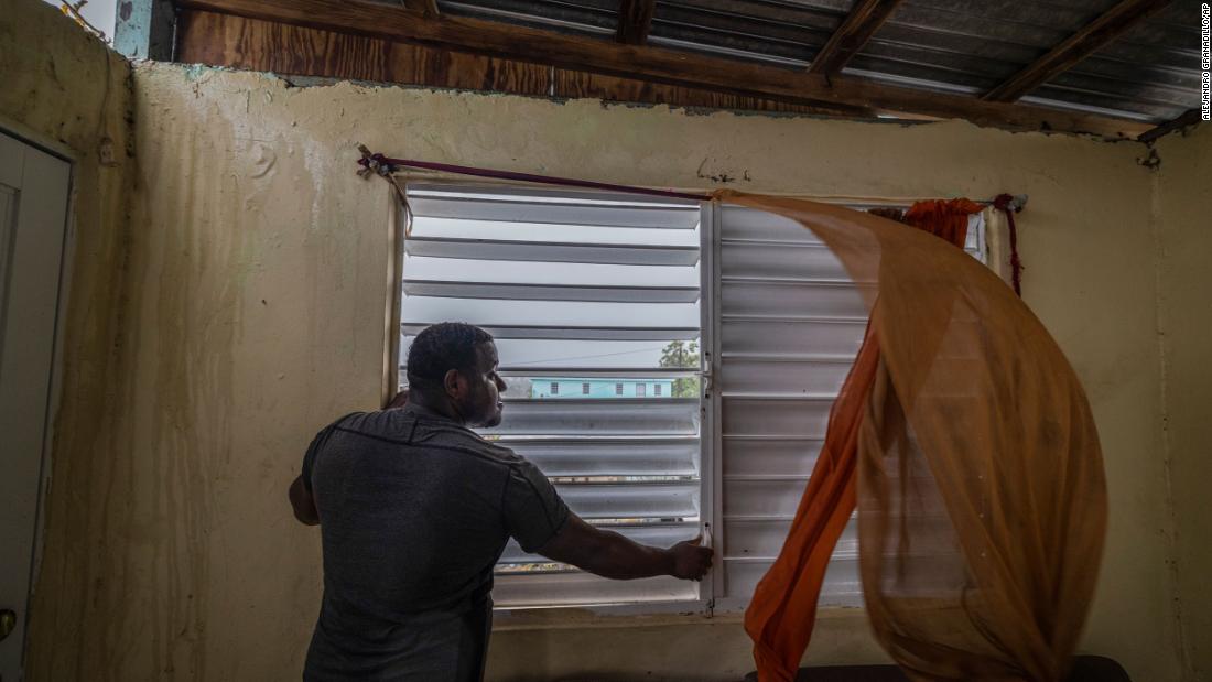 Nelson Cirino secures the windows of his home as the winds of Hurricane Fiona blow in Loíza on Sunday.