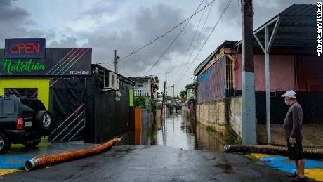 A man looks down a flooded street after Hurricane Fiona passed through the Juana Matos neighborhood of Catano, Puerto Rico. 
