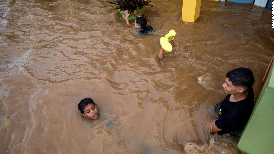Children swim in a flooded street in Salinas on Monday.