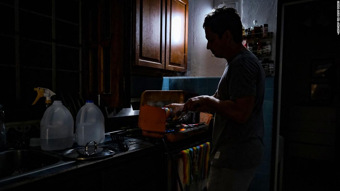 A person cooks in the dark Monday after losing power in San Juan, Puerto Rico.