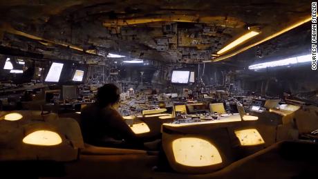To envision this view of the interior of a freighter, Stelzer fed Midjourney the prompt &quot;hi-res 35mm footage of the inside of a large space ship freighter control room, in the center there is a person sitting on a chair, dark and beige atmosphere, dark electronics, salt crusts on the wall, sparse LEDs.&quot;
