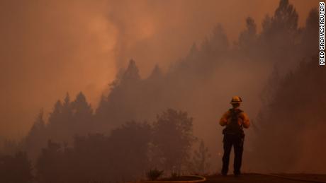 A firefighter watches the Mosquito Fire while protecting structures on September 13.