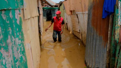 Nicasio Gil walks through the stagnant water left by the swollen Duey river, caused by Hurricane Fiona in the Los Sotos neighborhood in Higüey, Dominican Republic, Tuesday, Sept. 20, 2022.(AP Photo/Ricardo Hernandez)