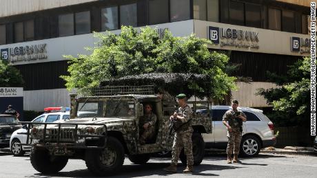 جنود الجيش اللبناني يؤمنون المبنى القريب من أحد البنوك في بيروت بعد أن اقتحم مودع الفرع مطالبته بالحصول على أمواله.