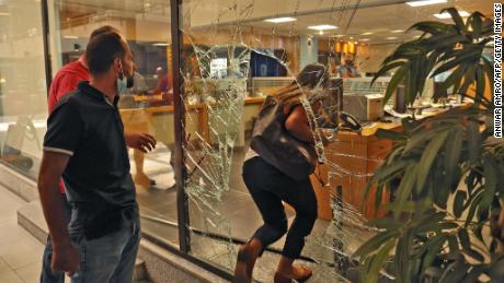 The glass window of a bank is broken after a woman stormed it on September 14.