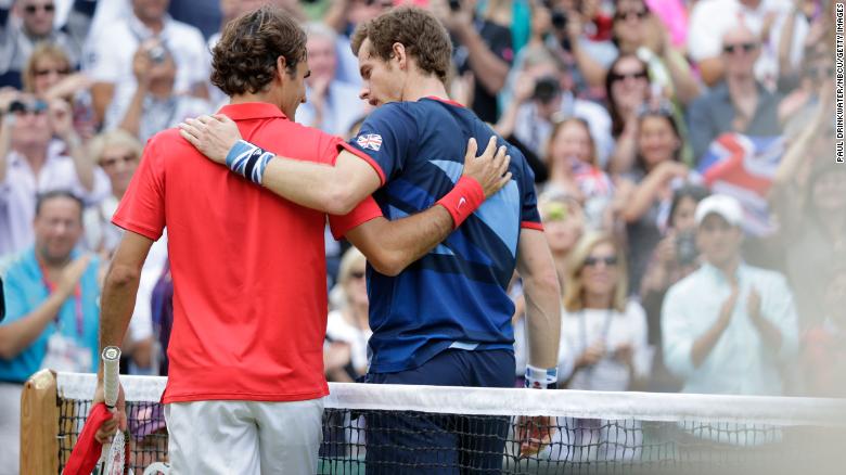 Federer walks off the court with Murray after Murray defeated him in the final of the 2012 Olympics in London.