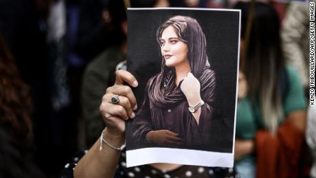 A protester holds a portrait of Mahsa Amini during a demonstration in her support in front of the Iranian embassy in Brussels, Belgium on September 23, 2022, 