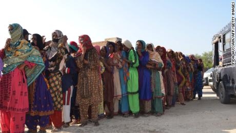 Flood victims line up to receive food aid in Dera Allah Yar town of Jaffarabad district in Balochistan province on September 17, 2022.