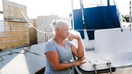 Jacqueline Rivera leans on the boat she and her husband used for shelter during Hurricane Fiona in Salinas, Puerto Rico.