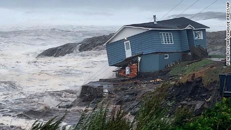 A home fights high winds from Post-Tropical Storm Fiona in Port aux Basques, Newfoundland and Labrador on Saturday.