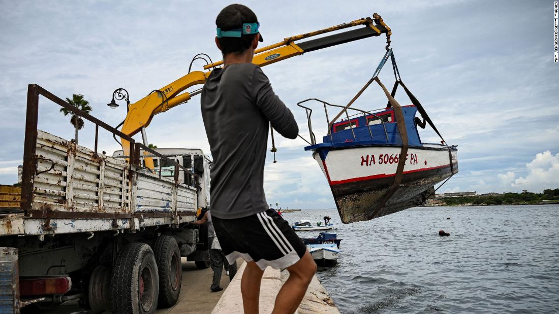 A man helps pull small boats out of Cuba&#39;s Havana Bay on Monday.