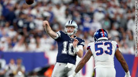 Cooper Rush throws a pass against Oshane Ximines of the New York Giants during the fourth quarter in the game.