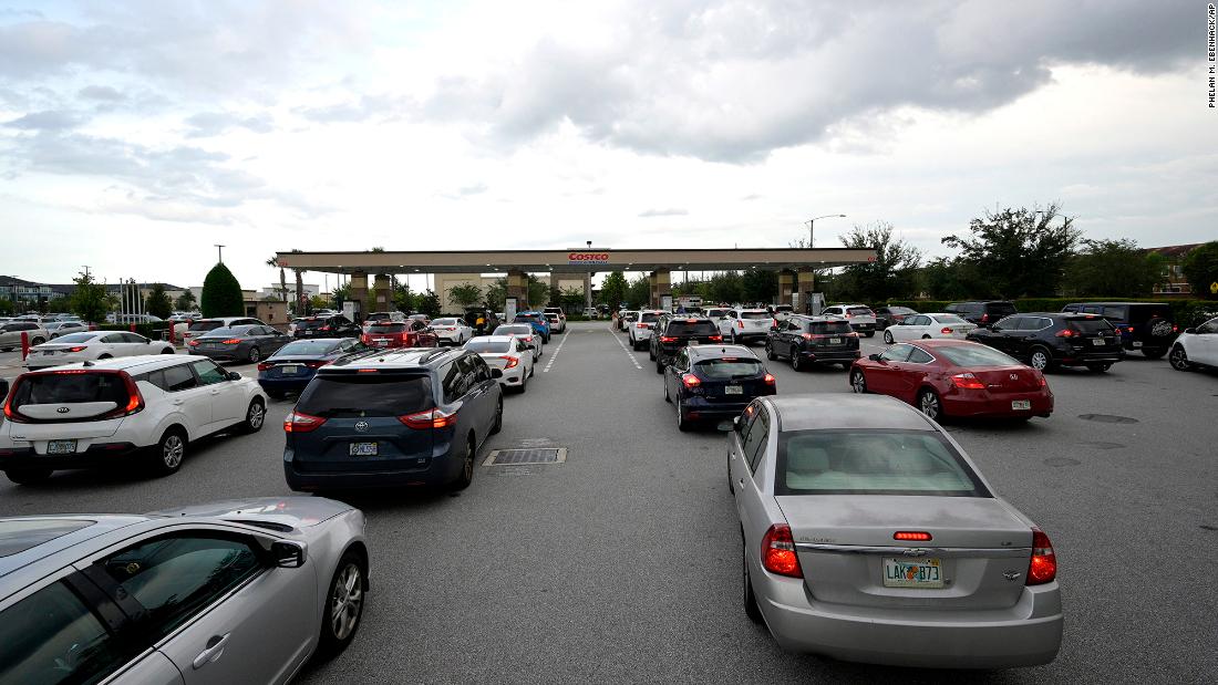People wait in lines to fuel their vehicles at a Costco store in Orlando on Monday.