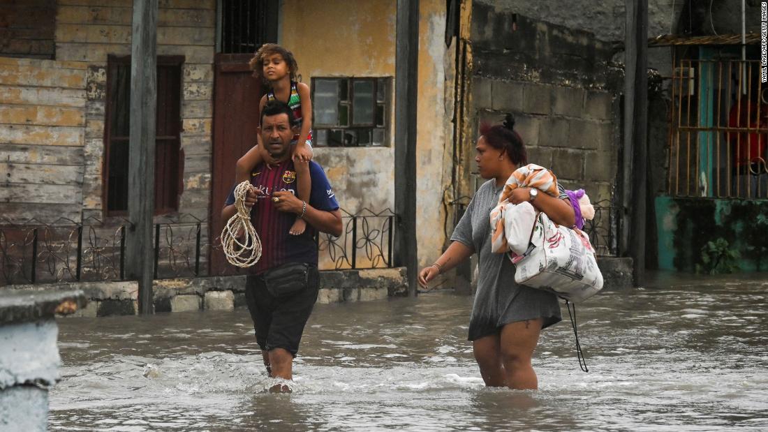People walk through a flooded street in Batabano, Cuba, on Tuesday.