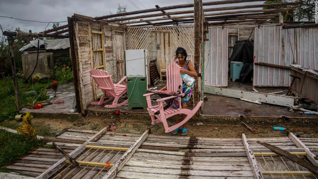 Maria Llonch retrieves belongings from her home in Pinar del Rio, Cuba, on Tuesday.