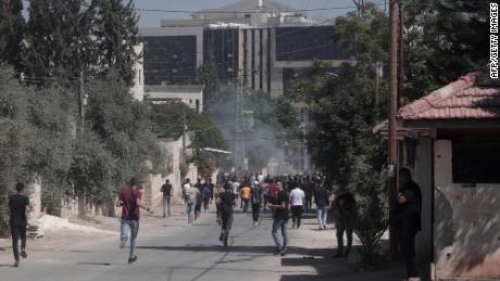 Palestinians run during clashes with Israeli forces in the city of Jenin on September 28, 2022. 