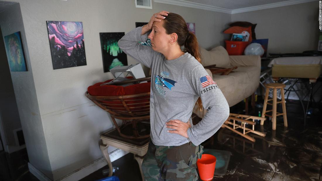 Stefanie Karas stands in her flooded apartment in Fort Myers on Thursday. She is an artist and was salvaging what she could from her home.