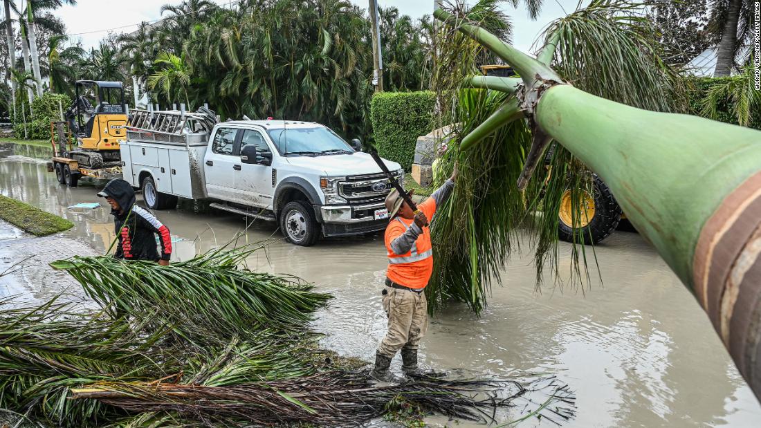 Workers in Naples, Florida, clean up debris on Thursday.