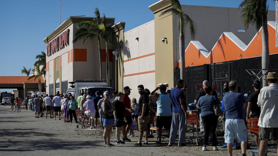 People wait in line to enter a Home Depot store in Cape Coral, Florida, on Friday. Many in Florida were still without power.
