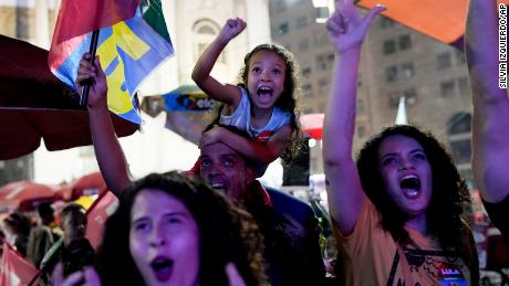 Followers of former Brazilian President Luiz Inacio &quot;Lula&quot; da Silva react as they listen to the partial results after polls closed in Rio de Janeiro on October 2, 2022. 
