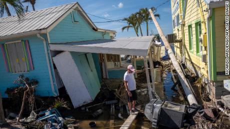 A man stands in front of his destroyed house in the aftermath of Hurricane Ian in Matlacha, Florida on October 3, 2022. - The confirmed death toll from Hurricane Ian, which slammed the southeast United States last week, has risen to at least 62, officials said October 2, 2022. 