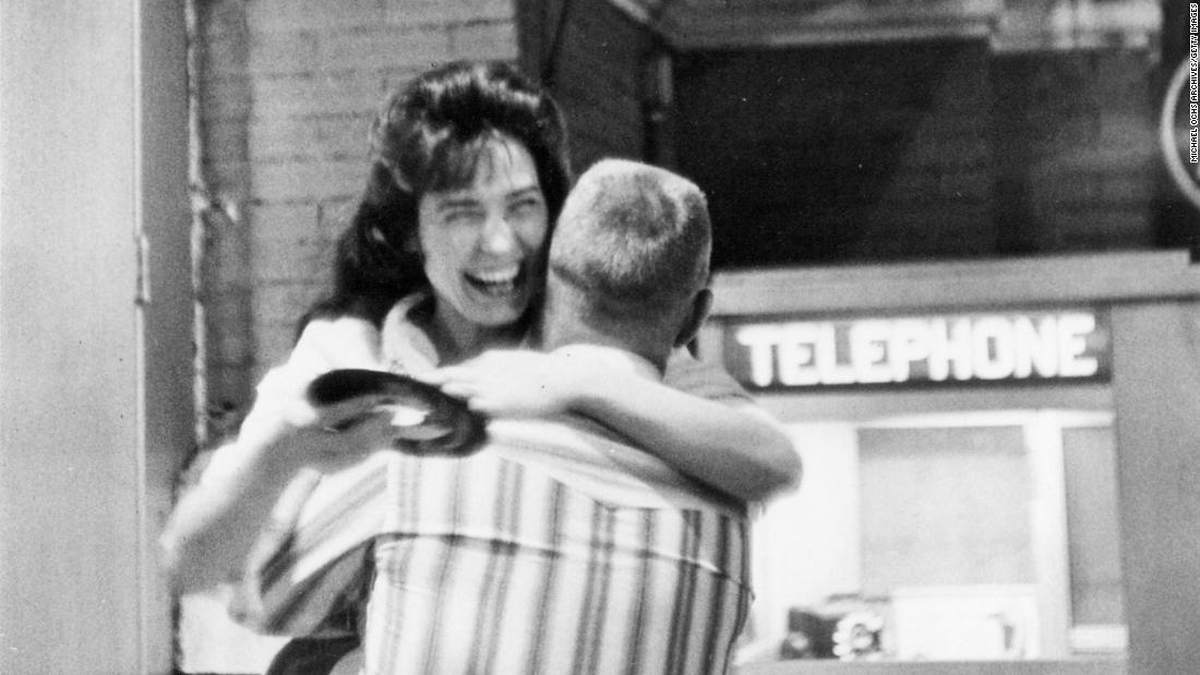 Lynn hugs a man while holding a record outside the Grand Ole Opry in Nashville, Tennessee, circa 1960. 