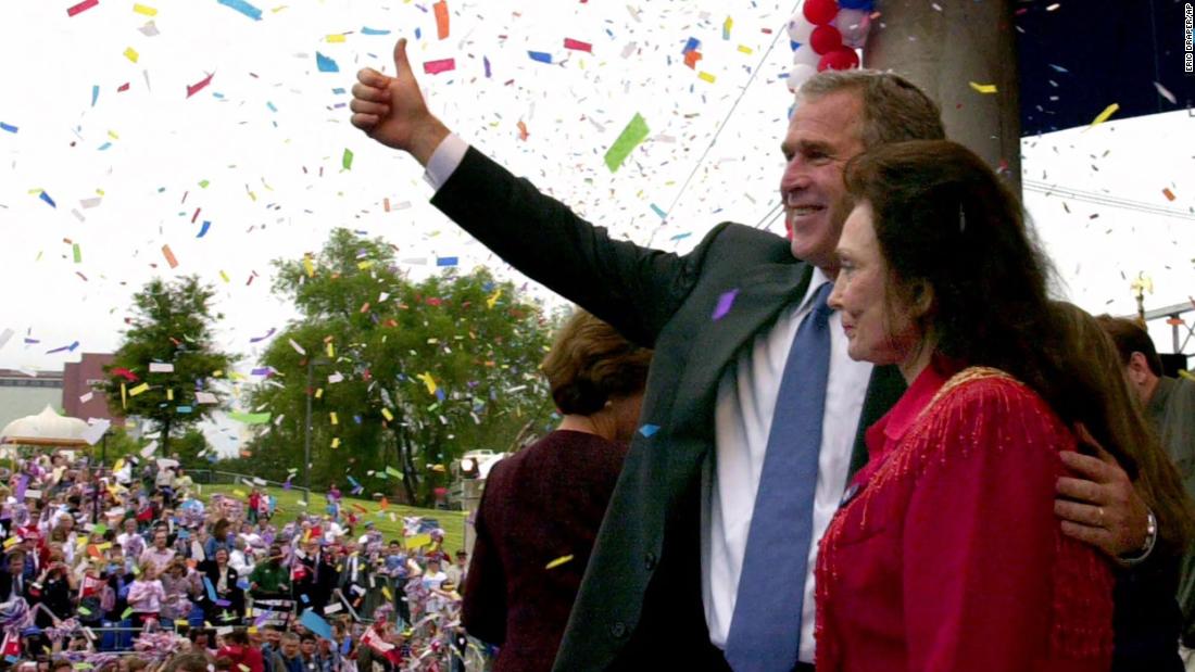 George W. Bush, then a Republican presidential candidate, is joined on stage by Lynn during a rally in Little Rock in 2000.