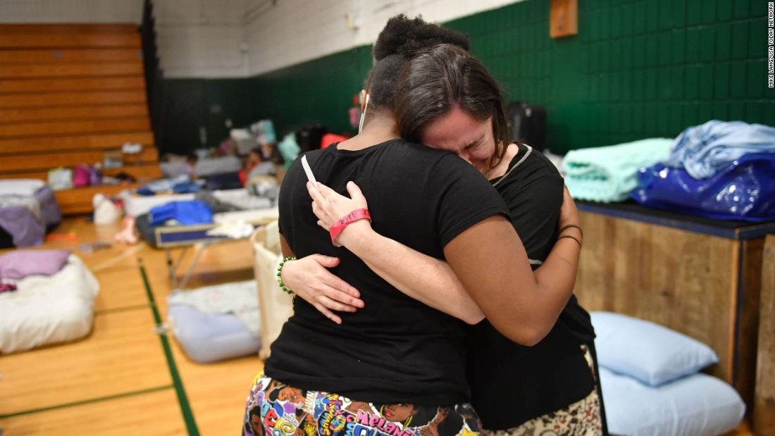 Stephanie Fopiano, right, gets a hug from Kenya Taylor, both from North Port, as she gets emotional about her situation at the Venice High School hurricane shelter in Venice, Florida, on Monday, October 3.