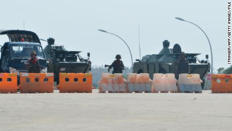 Soldiers stand guard on a blockaded road to Myanmar&#39;s parliament in Naypyidaw on February 1, 2021.