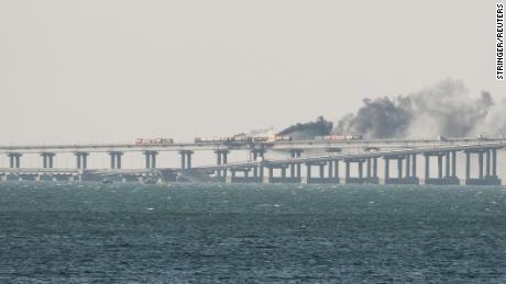A view shows fuel tanks ablaze and damaged sections of the Kerch bridge on October 8, 2022. 