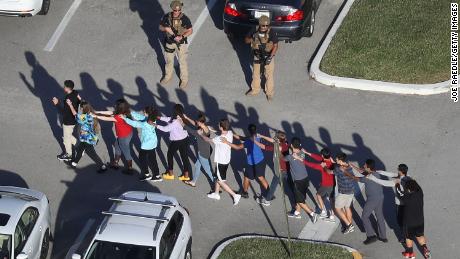 People are taken out of Marjory Stoneman Douglas High School after a gunman killed 17 on February 14, 2018.