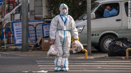 A worker wearing protective gear crosses the road near an area placed under lockdown due to Covid-19 in Beijing, China on October 12, 2022.