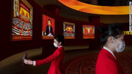 Hostesses stand near images showing Chinese President Xi Jinping at an exhibition highlighting Xi&#39;s years as leader, as part of the upcoming 20th Party Congress, on October 12, 2022 in Beijing, China.