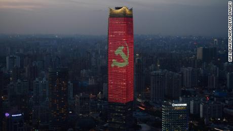 The Communist Party logo is seen on a skyscraper in Shanghai at dusk.