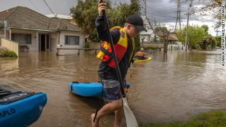 A resident in the suburb of Maribyrnong canoeing down a flooded street. 