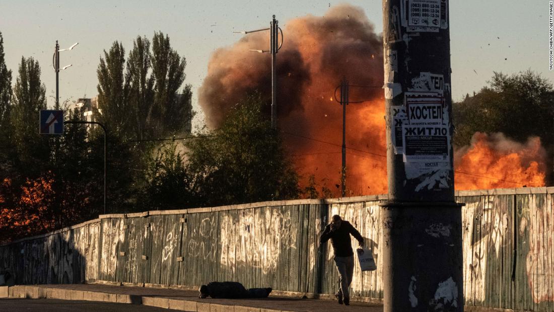 People react as a drone lands and explodes nearby in Kyiv on Monday.