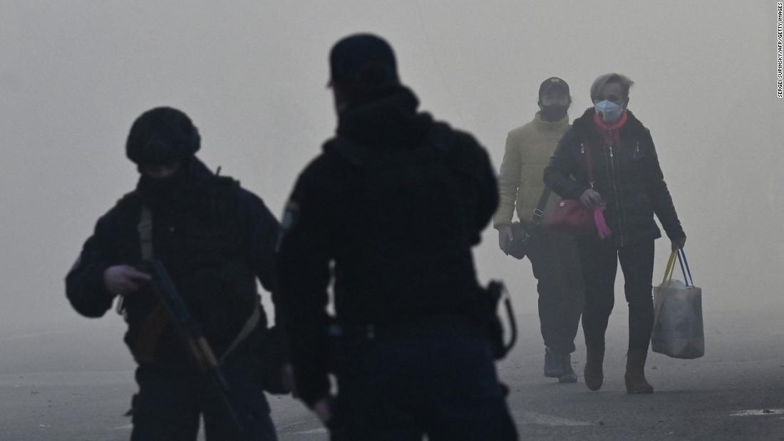People walk through smoke after a drone attack in Kyiv.
