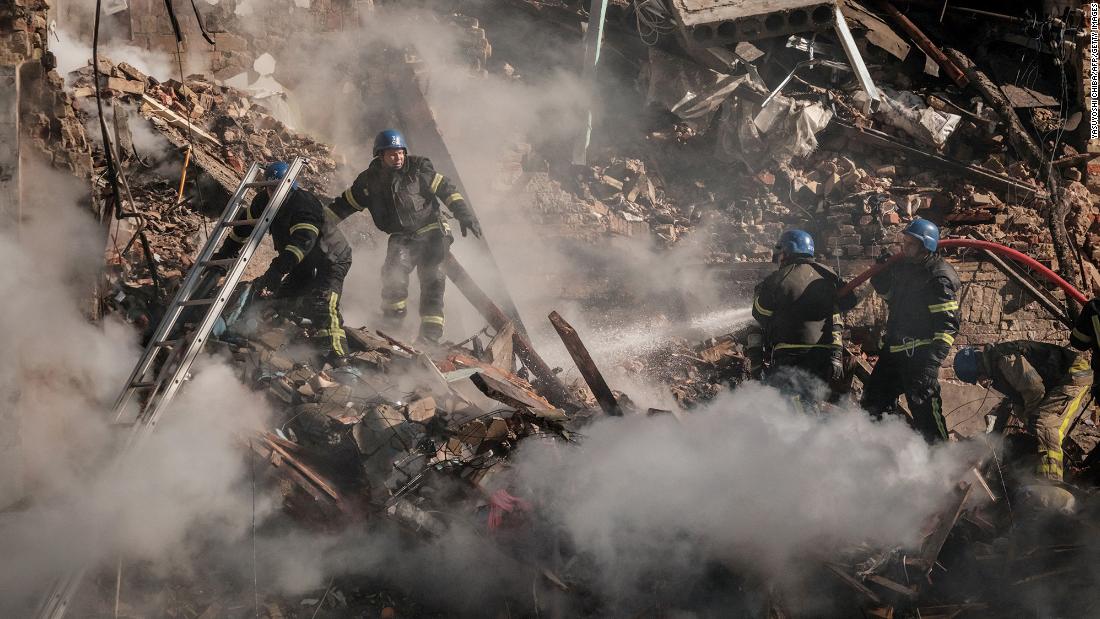 Ukrainian firefighters search a destroyed building after a drone attack in Kyiv on October 17.
